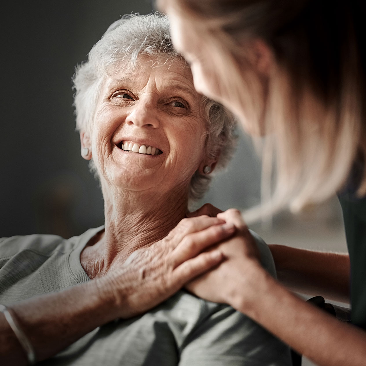 Une femme souriante aide une personne âgée